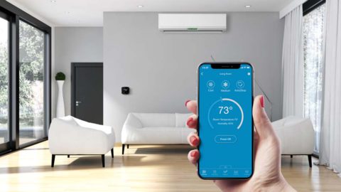 Cielo Breez connected with a mini-split. A woman is using Cielo home app to control the room temrpature.