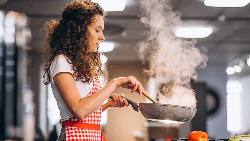  Ragazza che cucina in cucina.