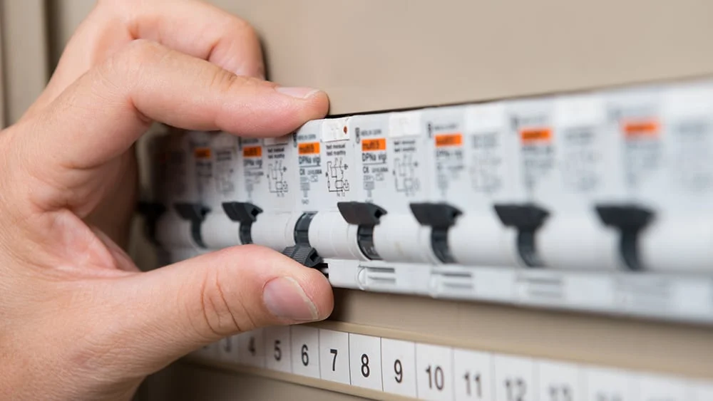 Man turning on circuit breaker. 