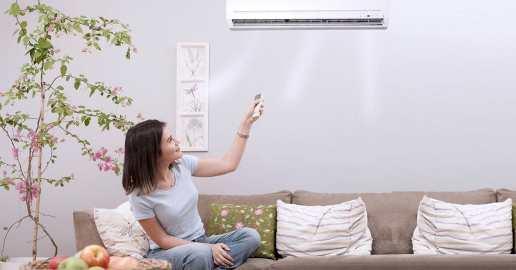A woman controlling AC with a remote