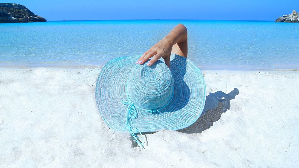 Woman wearing a blue hat, relaxing in a beach