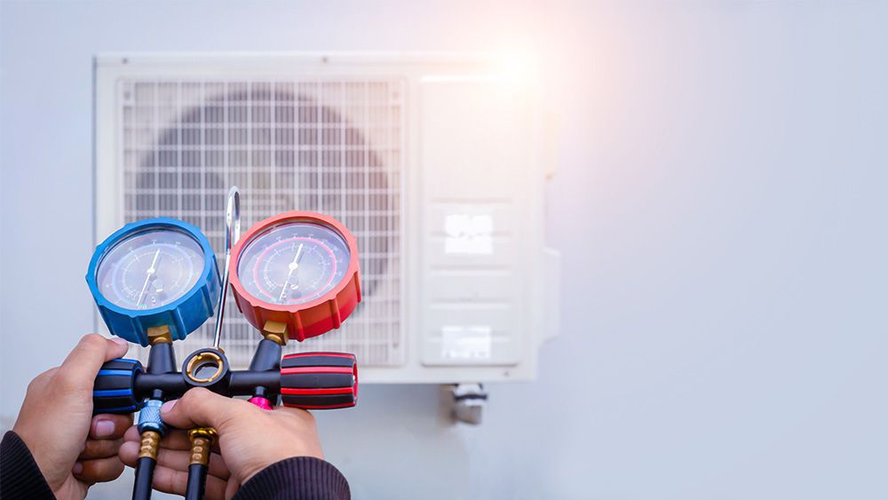 HVAC technician measuring AC refrigerant levels