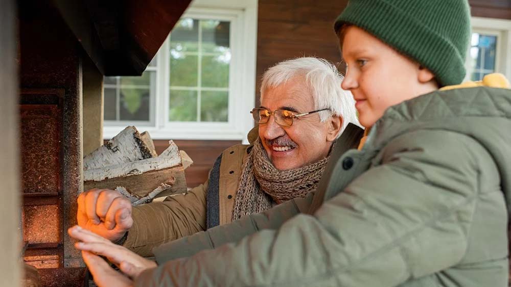 father and son warming their hands in front of the heater