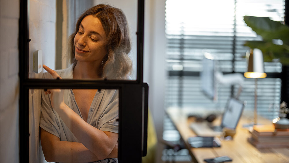 A girl changing settings on her white thermostat