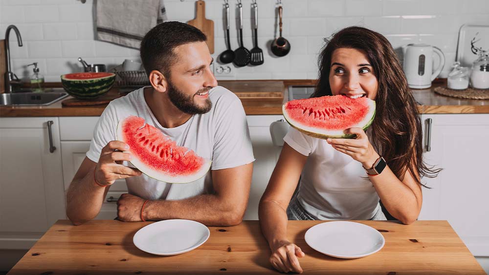 Man and woman enjoying water melon in summer season