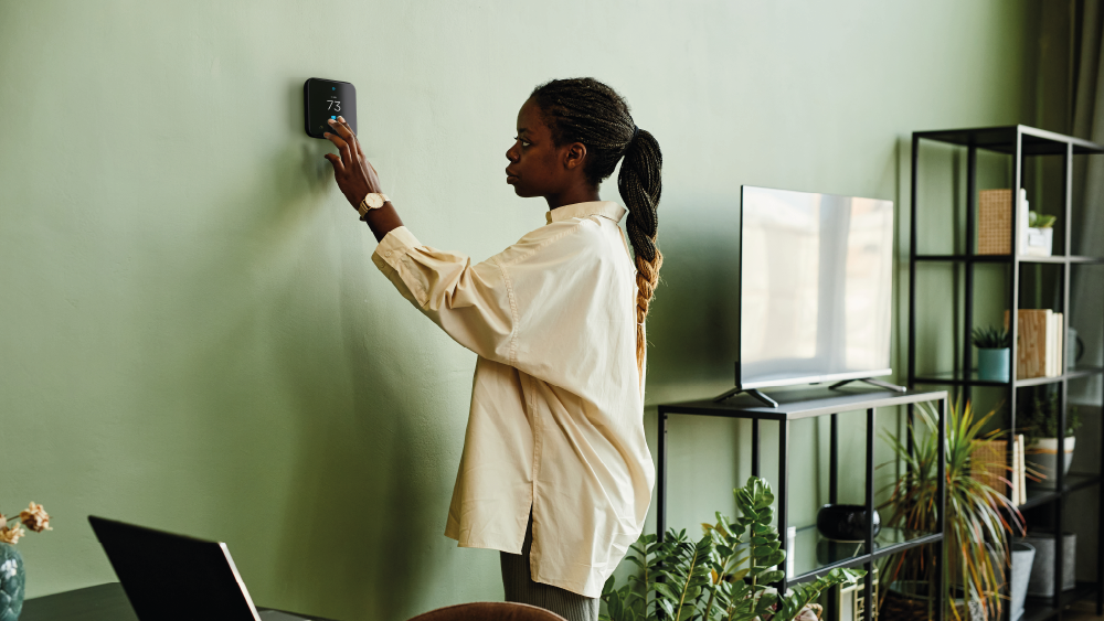 Woman adjusting temperature on Cielo WiFi smart thermostat