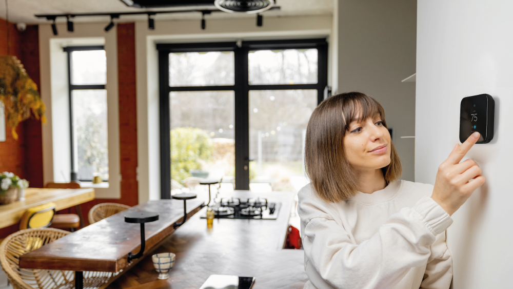 A woman using Cielo smart thermostat in her home