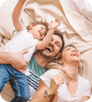 Family laughing on bed