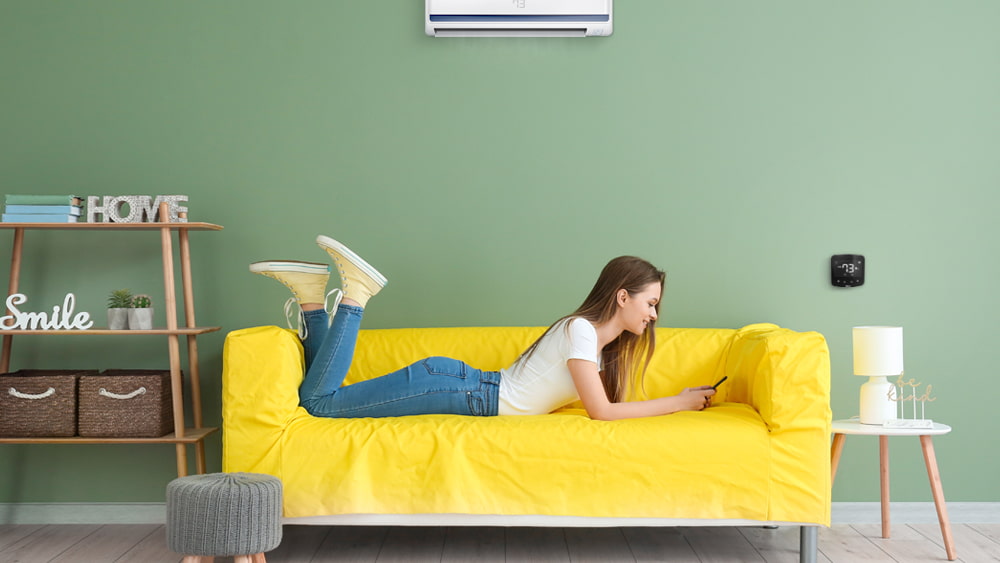 Woman using Cielo Breez Plus to set AC schedule