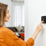 woman adjusting Cielo Smart Thermostat