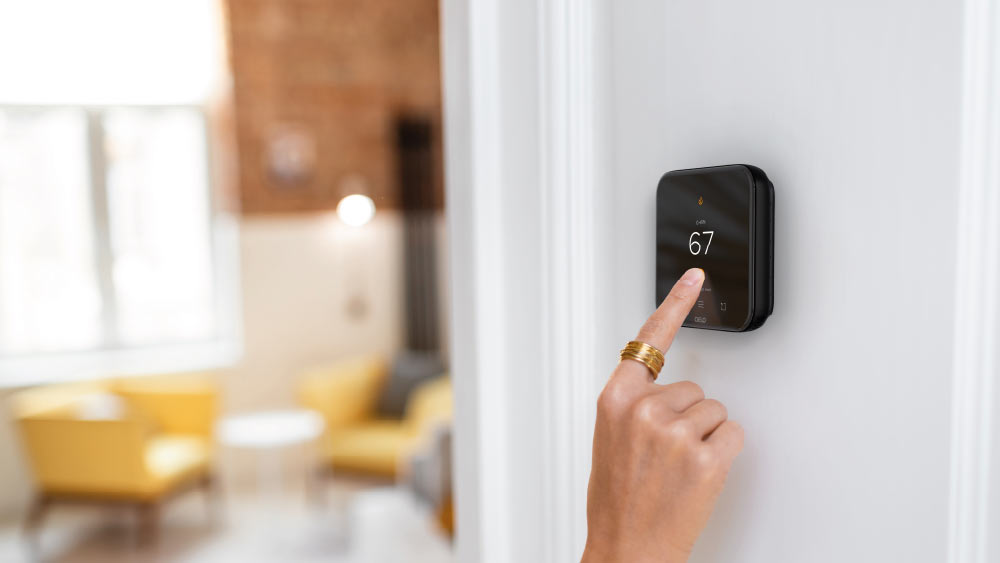 woman adjusting temperature on Cielo smart thermostat 