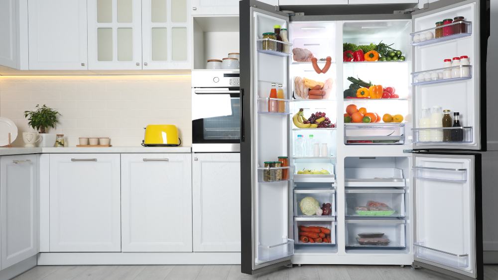 Open refrigerator in kitchen showing what uses most electricity in a home. 
