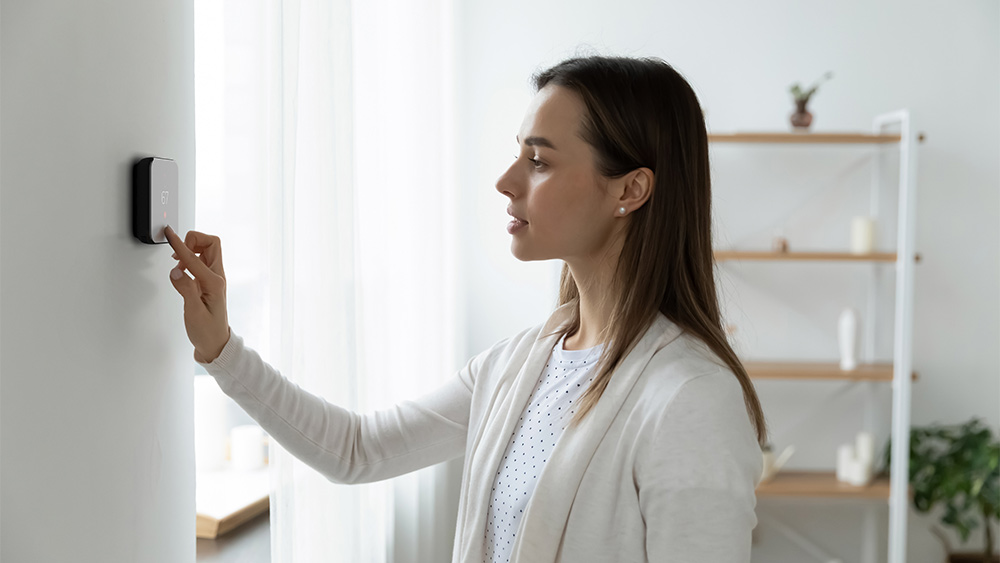 woman adjusting settings on cielo smart thermostat