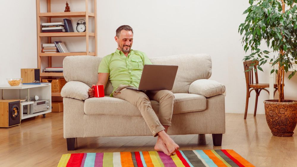 man sitting in living room choosing between forced air and central air