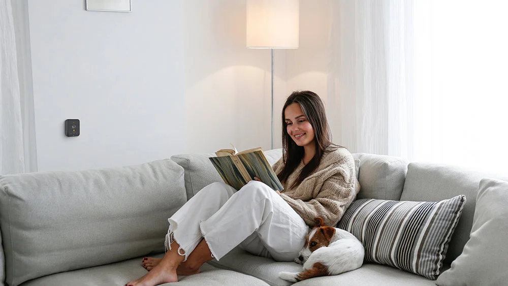 woman relaxing and reading a book with CST on wall