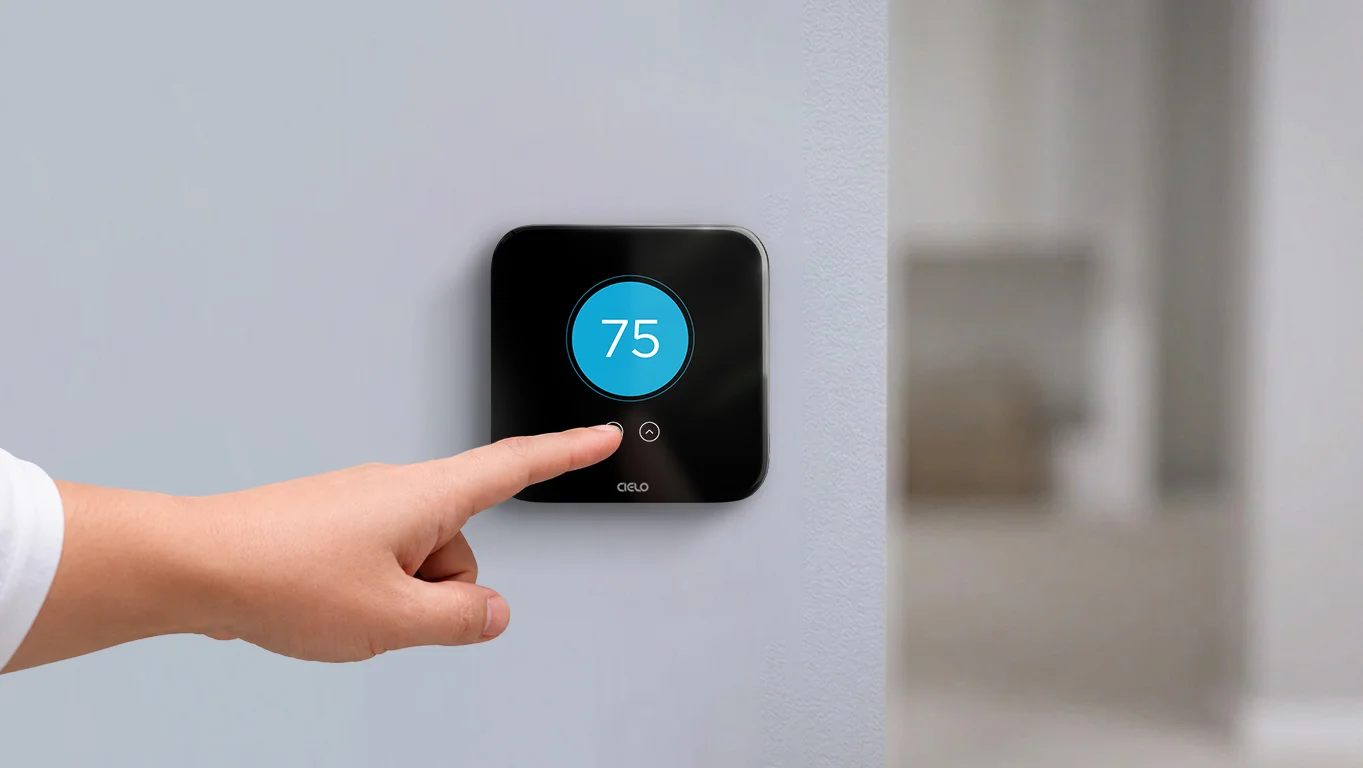 A person adjusting temperature on cielo smart thermostat